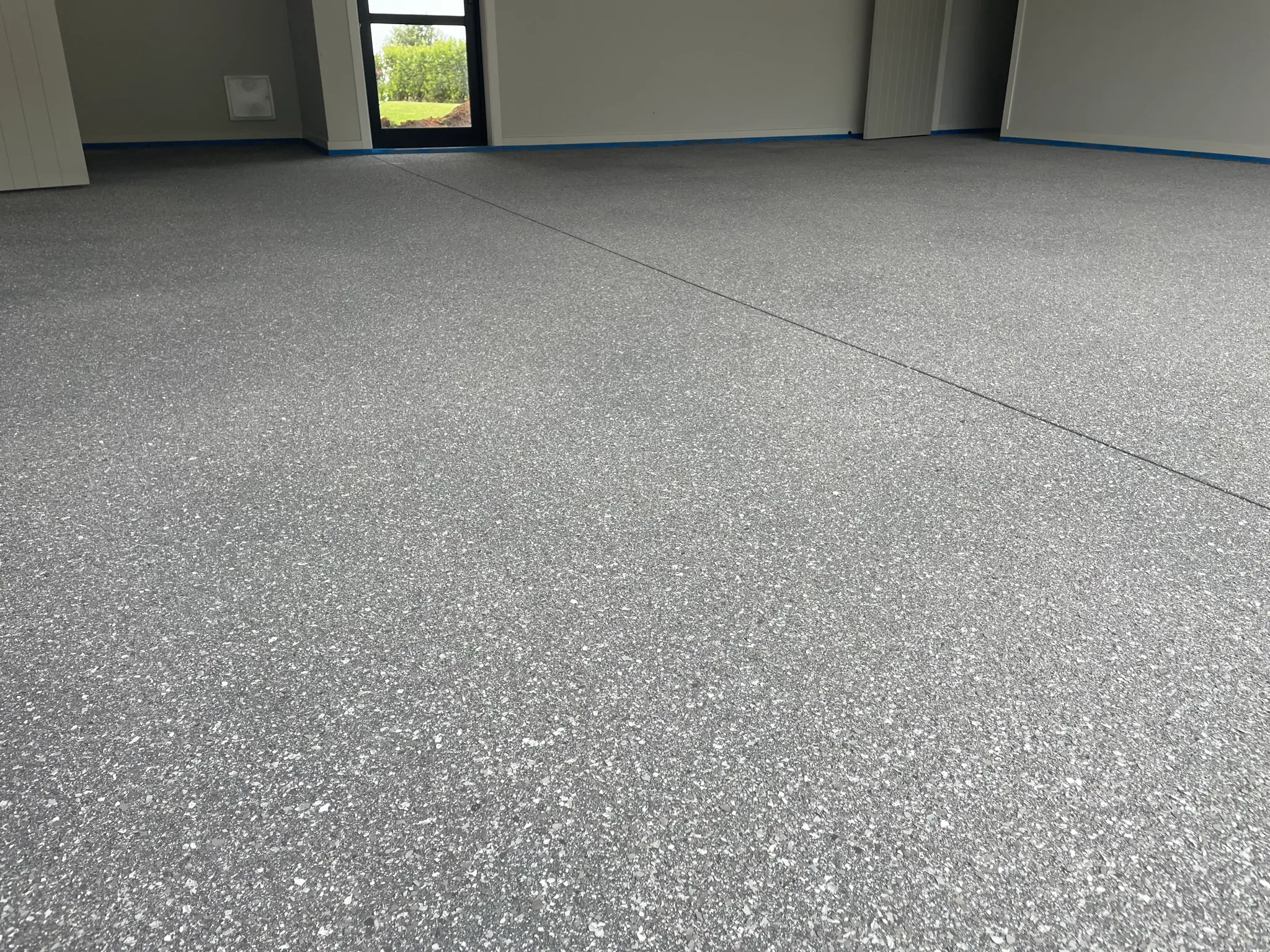 Freshly laid grey flake epoxy floor by Apollo Flooring in an Auckland garage